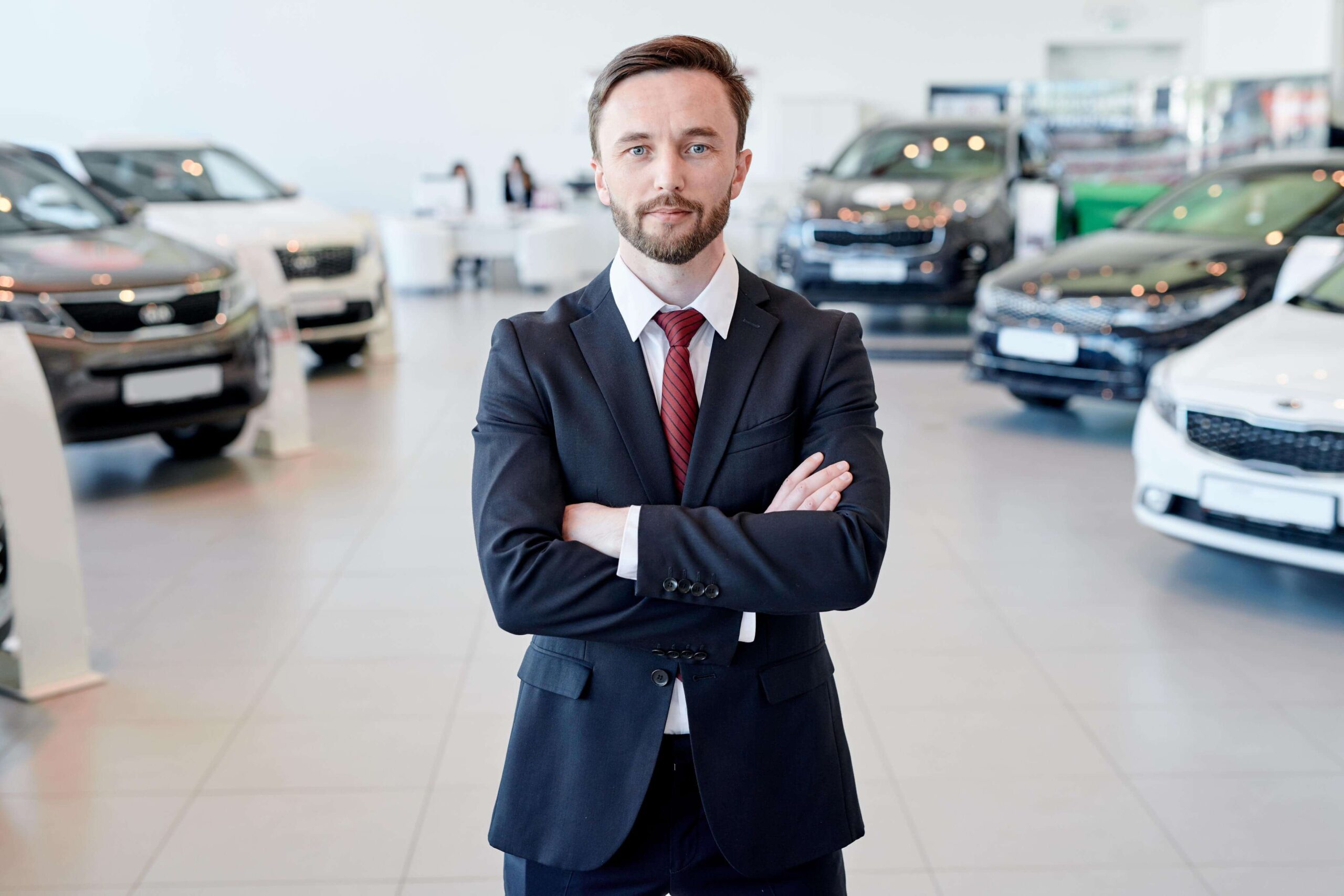 Car Salesman Posing In Showroom Z4FEB2P Scaled 1